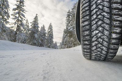 Snow covered road with wheel of car