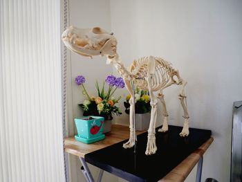 Flower vase on table against wall at home