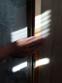 Close-up of hand touching window