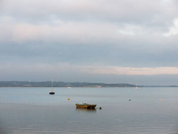 Sailboat sailing on sea against sky
