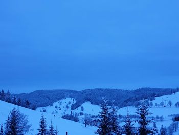 Scenic view of snowcapped mountains against blue sky