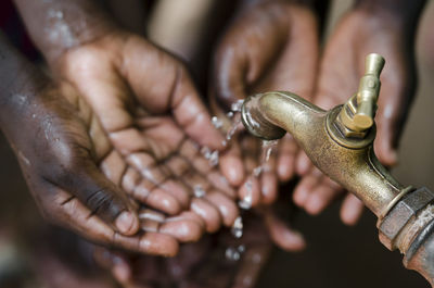 Close-up of hands under falling water from faucet