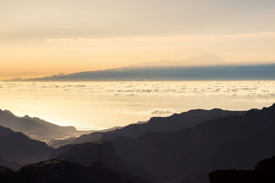 Scenic view of silhouette mountains against sky at sunset