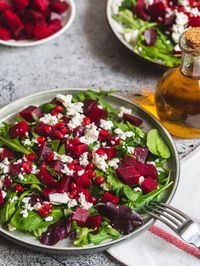 Arugula, beet and cheese salad with pomegranate and dressing on plate 