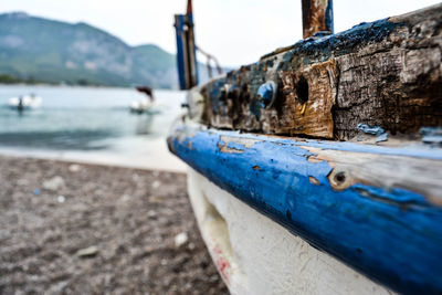 Close-up of rusty boat moored at shore