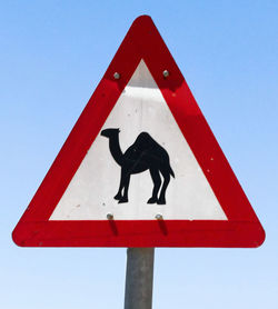 Low angle view of road sign against clear sky