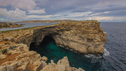 Rock formations in sea against sky