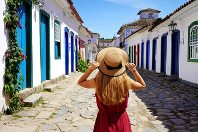 Back view of beautiful fashion girl enjoying visiting historic town of paraty, rio de janeiro,brazil