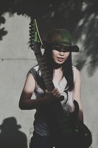 Portrait of a young woman holding guitar