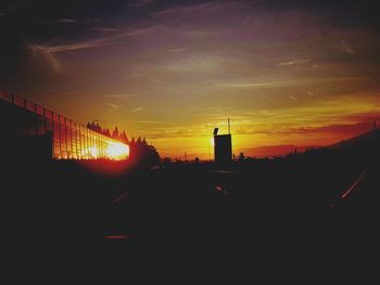 Silhouette buildings against sky during sunset