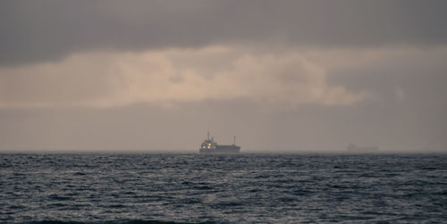 Boat sailing in sea against sky