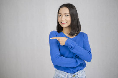 Portrait of a smiling young woman against white background