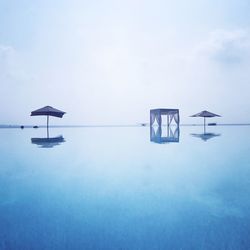 Lifeguard hut in sea against sky