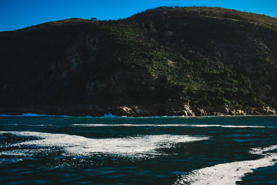 Scenic view of sea and mountains against sky