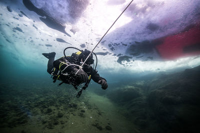 Scuba diver holding rope under water