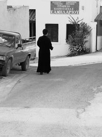 Rear view of woman on street against buildings in city