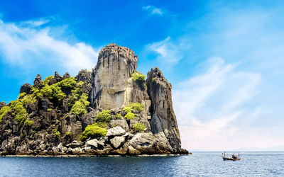 Low angle view of rock by sea against sky