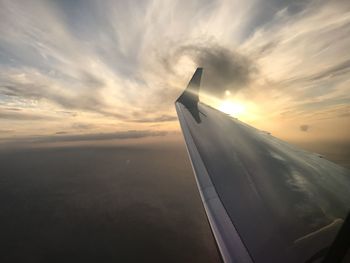 Close-up of airplane wing over sea against sky