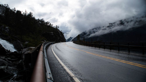 Road leading towards mountain against sky