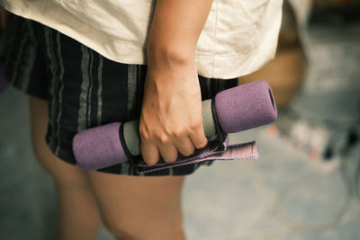 Midsection of man holding purple while standing outdoors