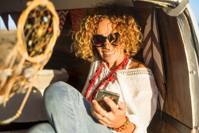 Smiling mature woman using phone in vehicle