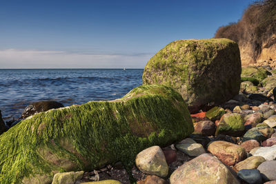 Rocks by sea against sky