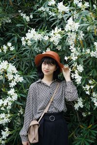 Portrait of beautiful woman standing against plants