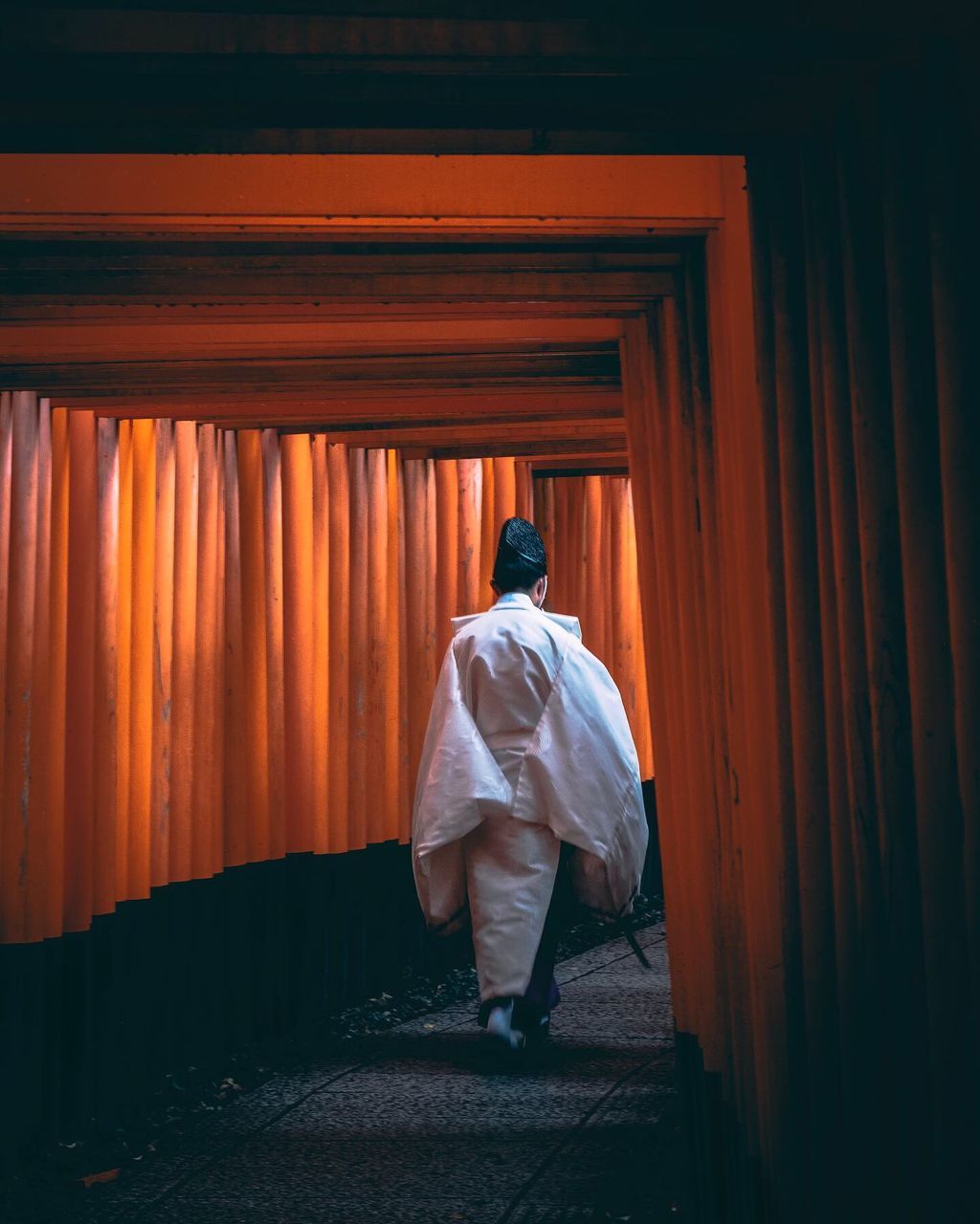 REAR VIEW OF MAN WALKING WITH ARMS RAISED