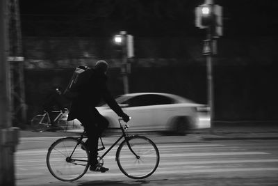 Man with bicycle on road in city