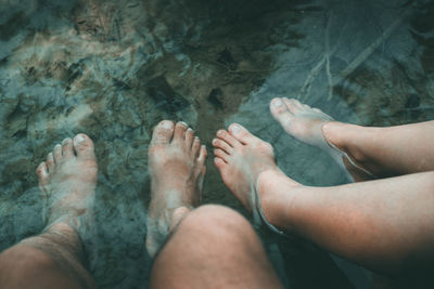 Low section of man and woman in water