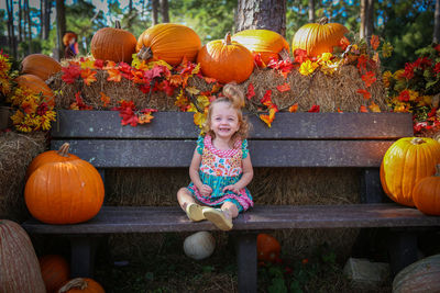 Smiling girl sitting on bench during halloween