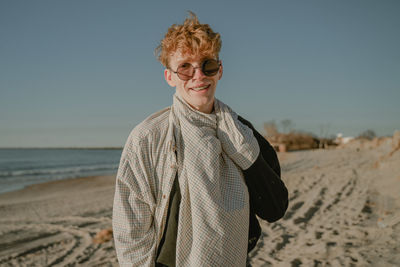 Portrait of young man standing at beach