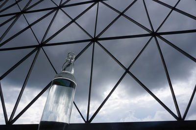 Low angle view of glass bottle against sky