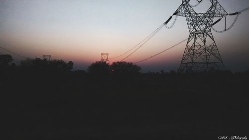 Silhouette of electricity pylon at sunset