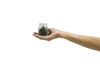 Close-up of hand holding bottle against white background