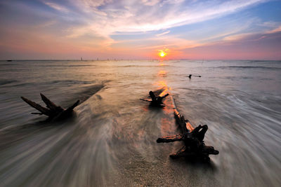 Scenic view of beach against sky during sunset