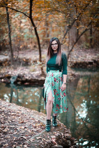 Portrait of woman standing against tree