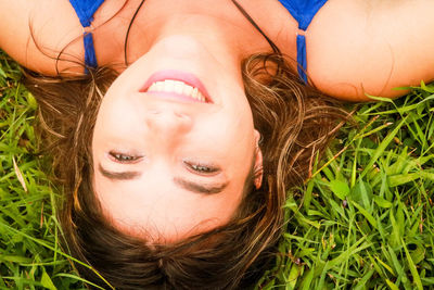 High angle portrait of woman lying on grass