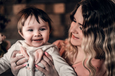 Close-up of mother carrying daughter at home