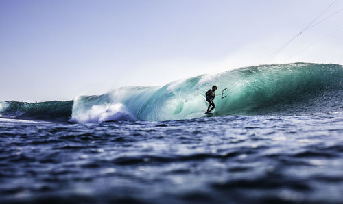 Man surfing in sea against sky