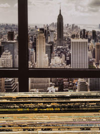 Stack of vinyl record sleeves in apartment with new york city skyline in background