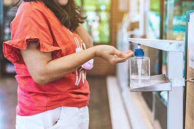 Midsection of woman holding ice cream in glass