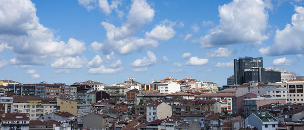 Buildings in town against cloudy sky