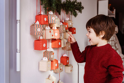 Full length of boy holding christmas at home