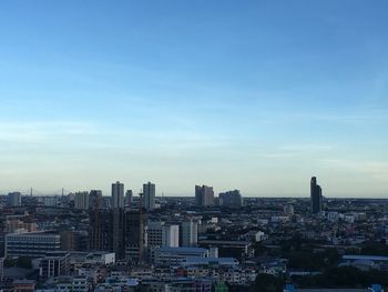 High angle view of modern buildings against blue sky