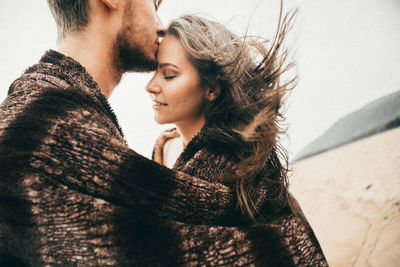 Midsection of couple kissing on land