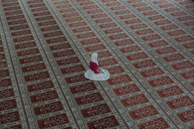High angle view of woman praying in mosque