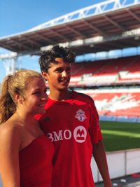 Teenage couple standing at stadium