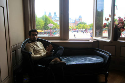 Man looking through window at home