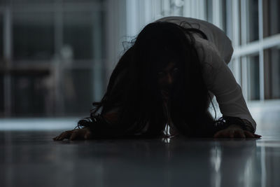 Portrait of young woman sitting on floor